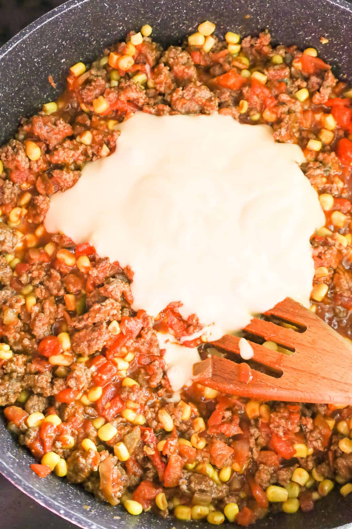 cheddar cheese soup added to skillet with ground beef, salsa and rotel mixture