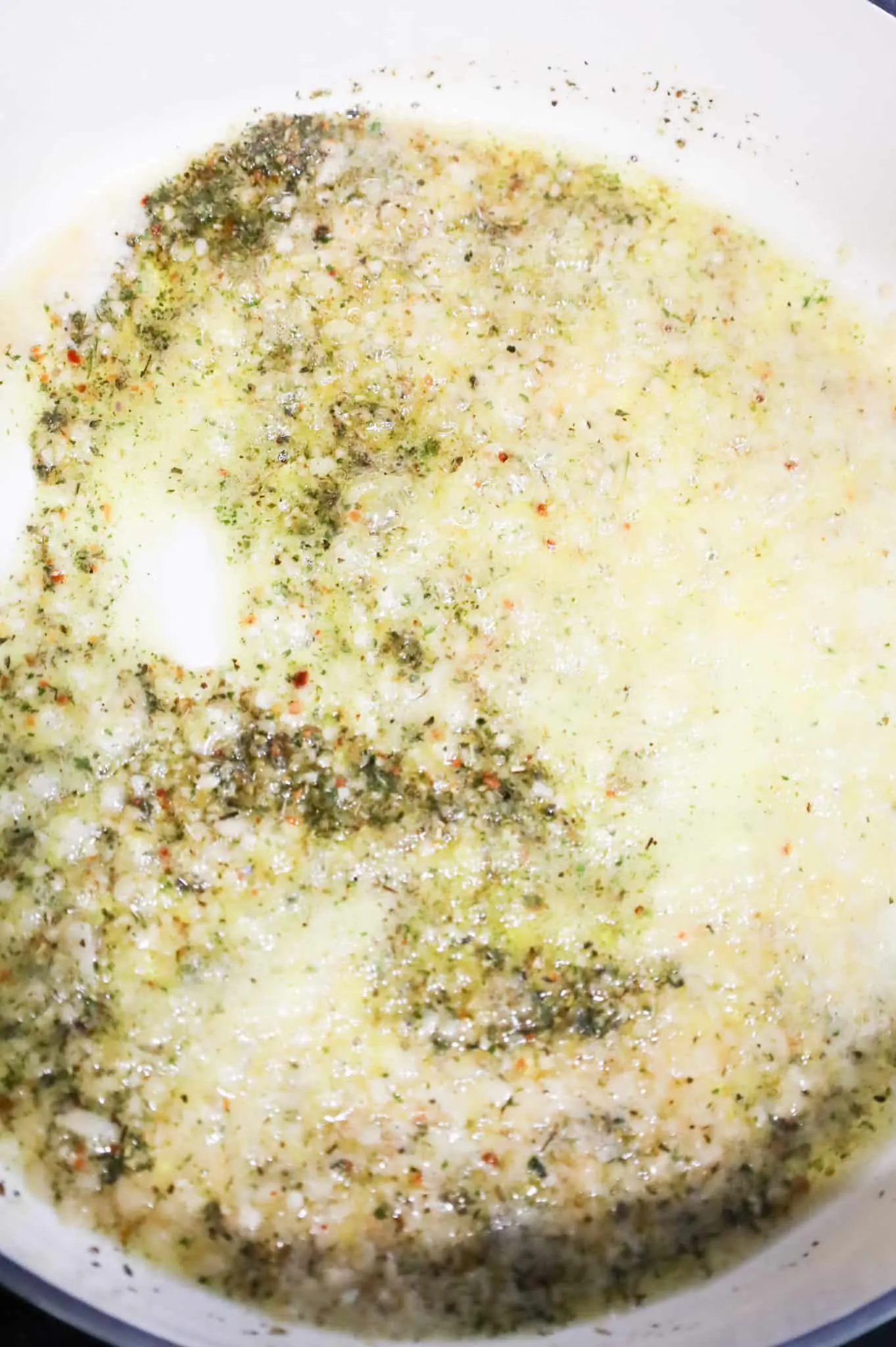 Italian seasoning, minced garlic and butter cooking in a skillet