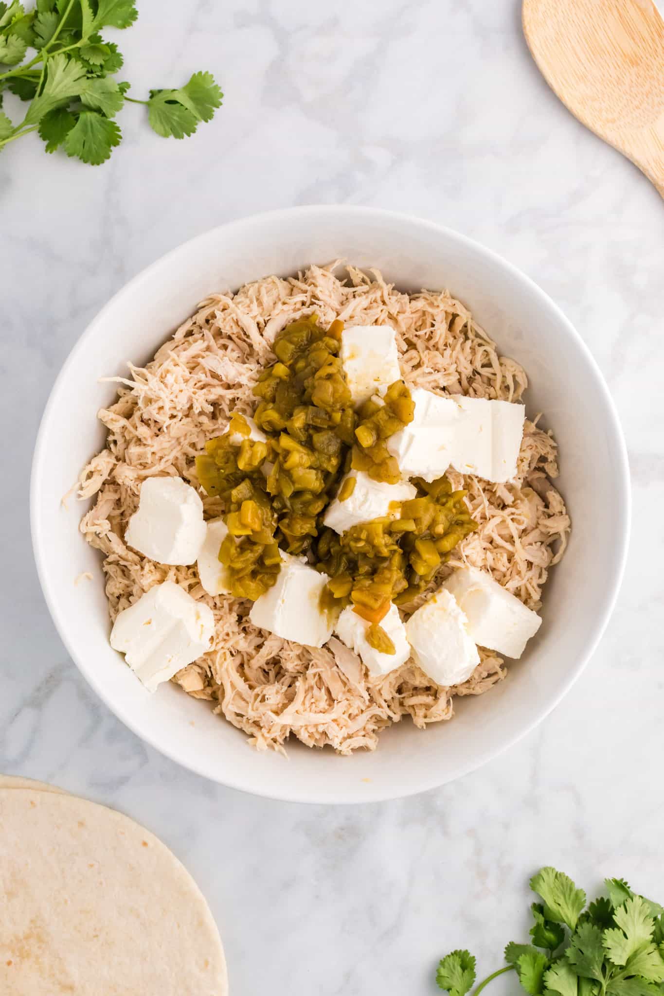 green chilis, cubed cream cheese and shredded chicken in a baking dish