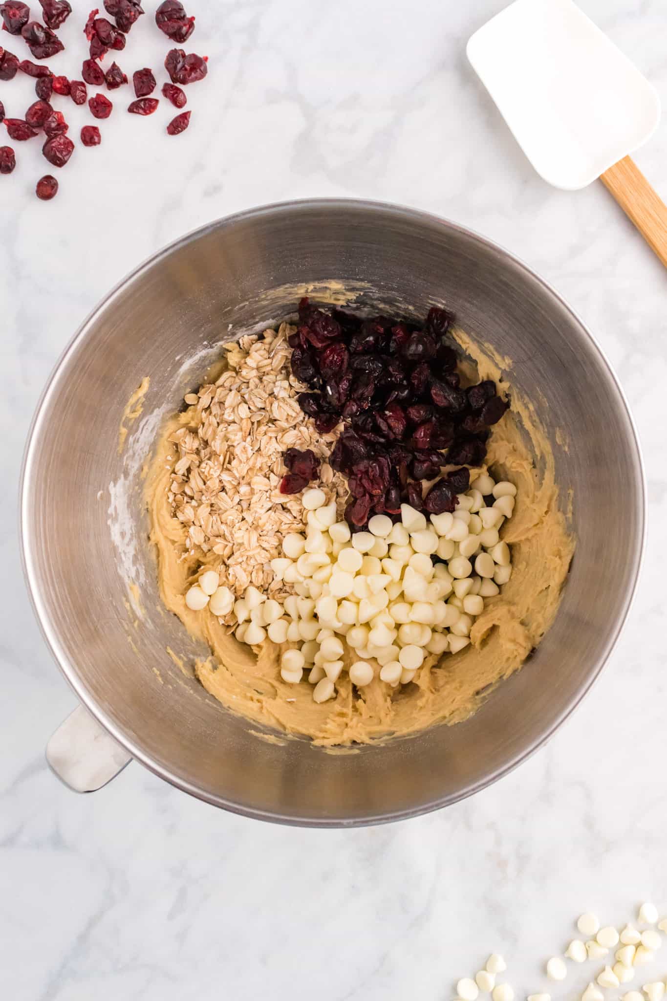 rolled oats, dried cranberries and white chocolate chips added to bowl with cookie dough
