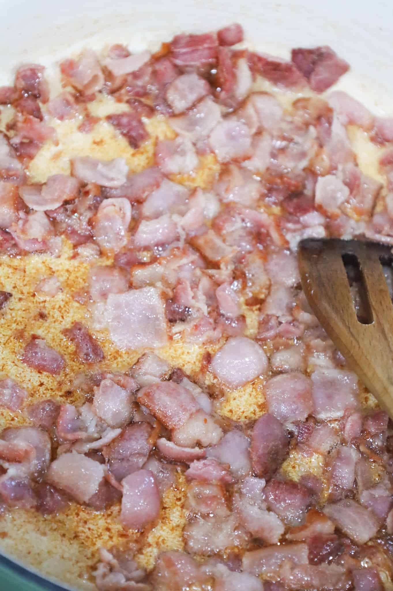 cooking bacon pieces in a skillet
