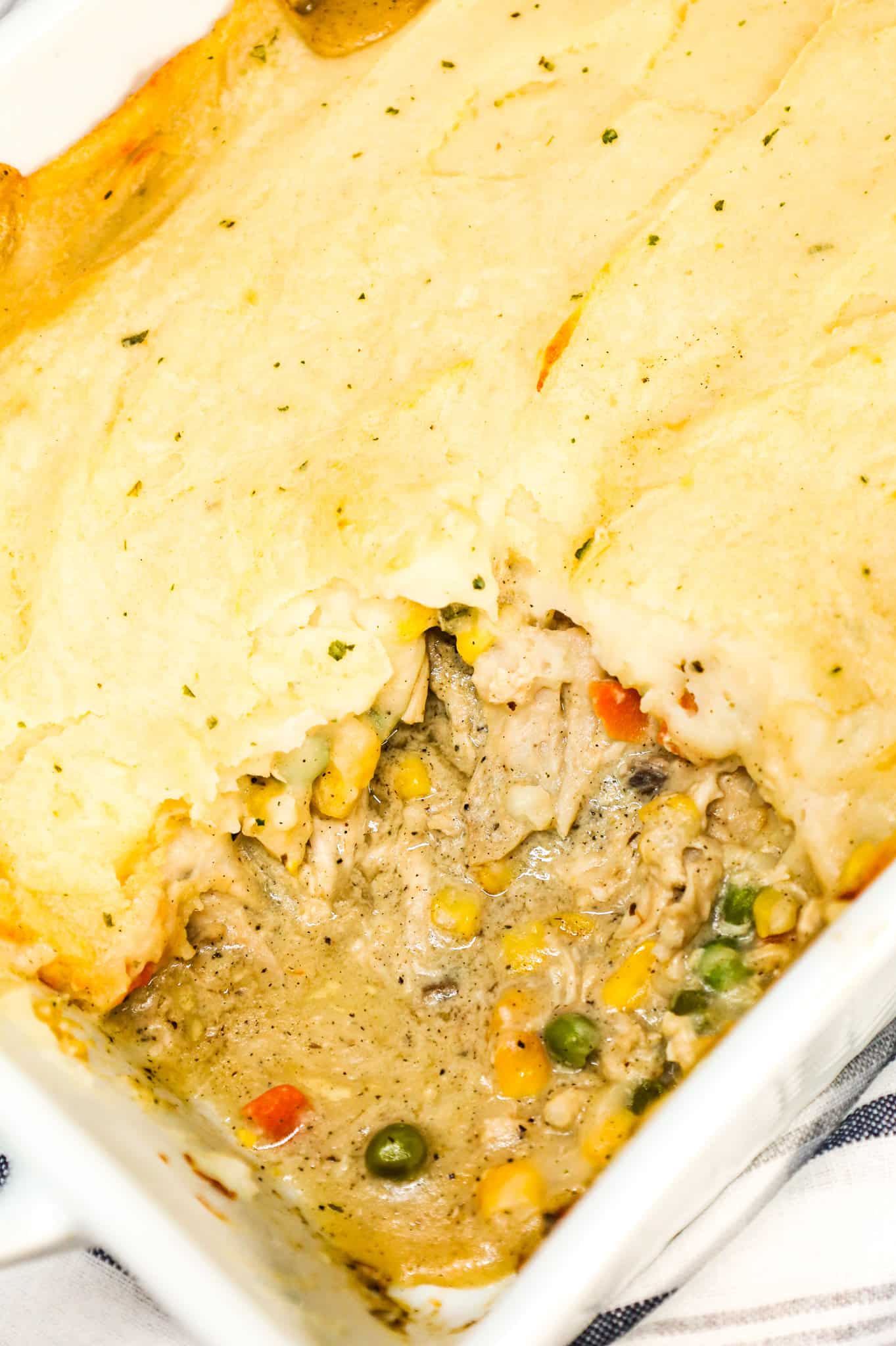 Chicken Shepherd's Pie is an easy dinner recipe loaded with shredded rotisserie chicken, mixed veggies, cream of mushroom soup and cream of chicken soup all baked with a layer of instant mashed potatoes on top.