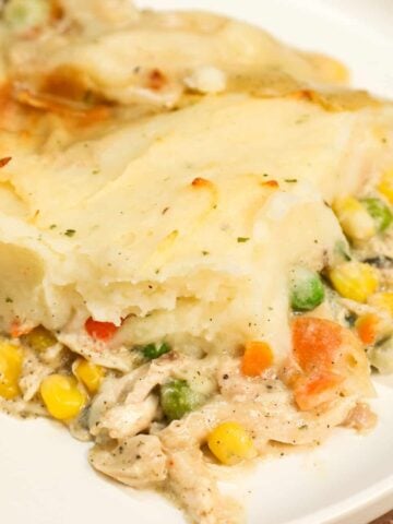 Chicken Shepherd's Pie is an easy dinner recipe loaded with shredded rotisserie chicken, mixed veggies, cream of mushroom soup and cream of chicken soup all baked with a layer of instant mashed potatoes on top.