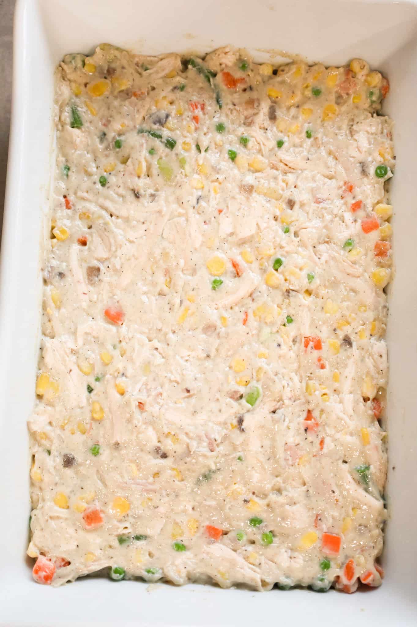 chicken, vegetable and cream soup mixture spread out in the bottom of a baking dish