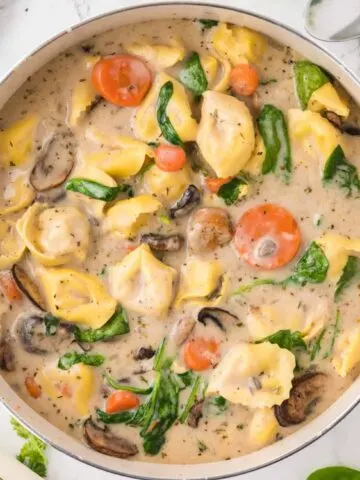 Creamy Tortellini Soup with Sausage is a hearty soup recipe loaded with store bought tortellini, chunks of sausage, mushrooms, carrots and spinach.