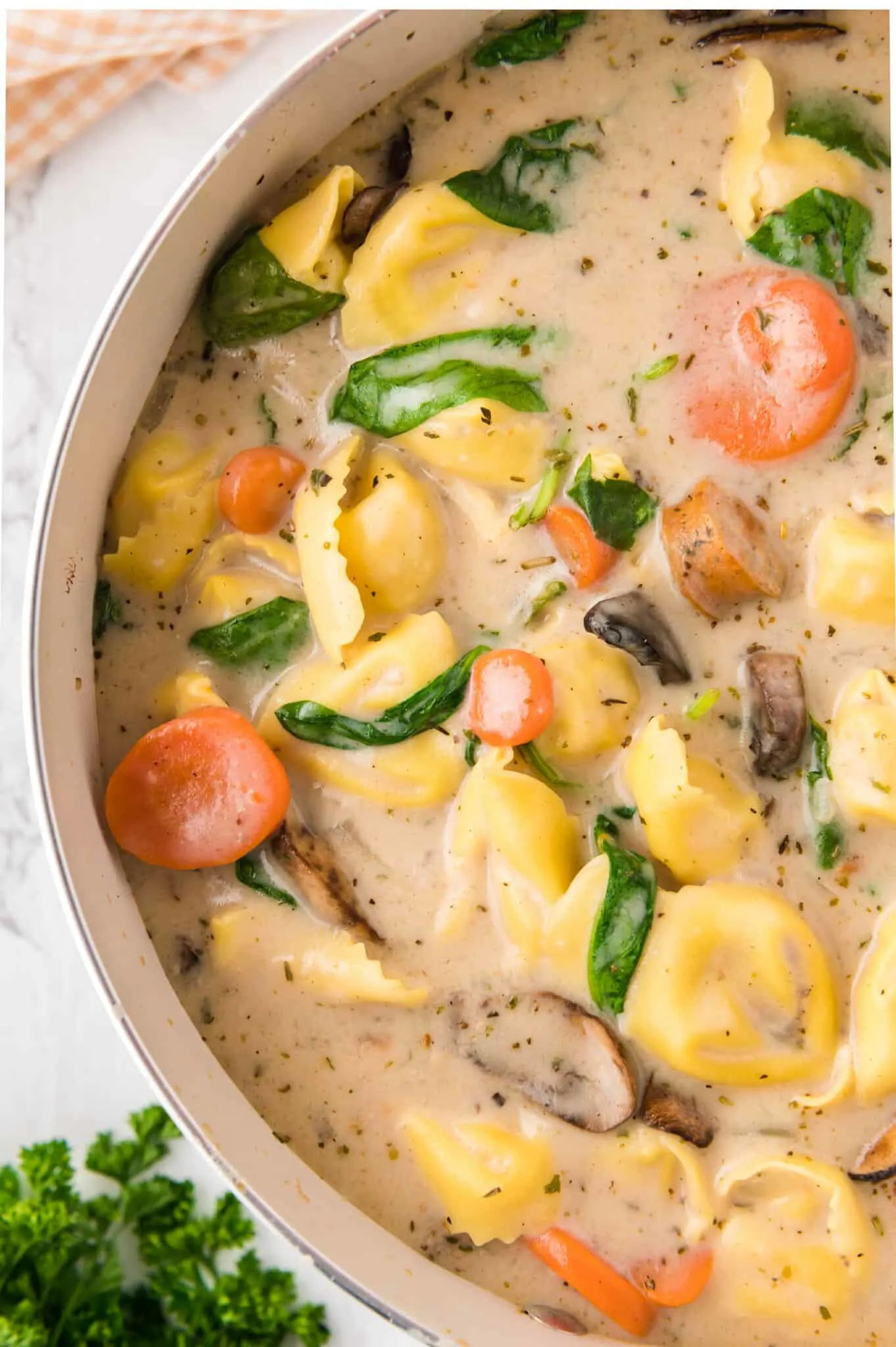 Creamy Tortellini Soup with Sausage is a hearty soup recipe loaded with store bought tortellini, chunks of sausage, mushrooms, carrots and spinach.