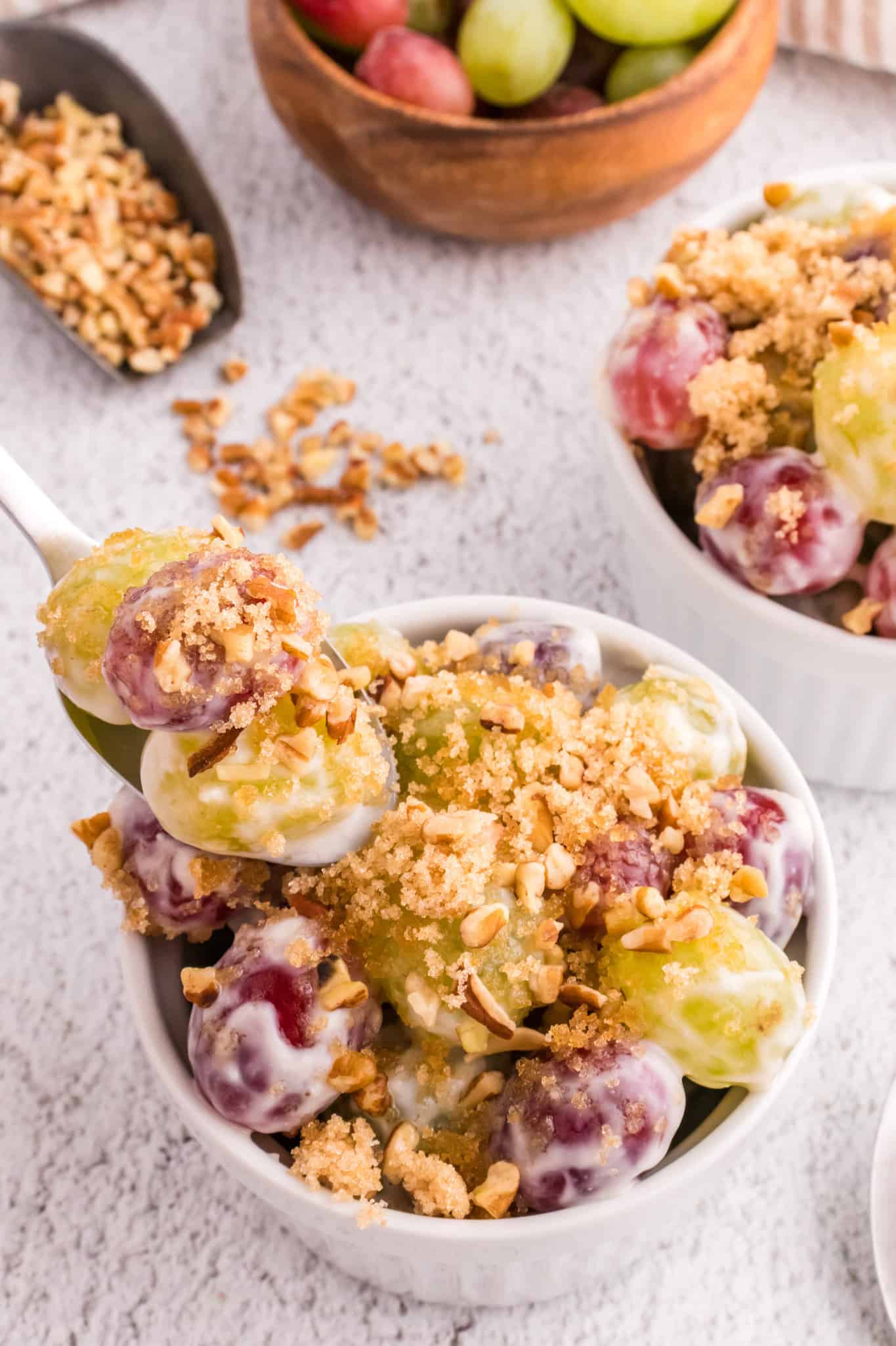 Grape Salad is a tasty side dish loaded with red and green grapes all tossed in a cream cheese and yogurt mixture and topped with brown sugar and chopped pecans.