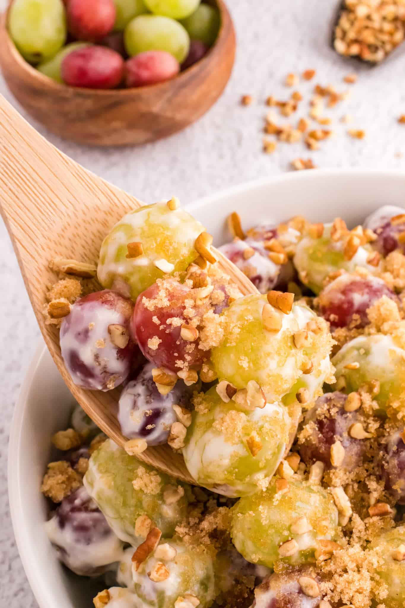 Grape Salad is a tasty side dish loaded with red and green grapes all tossed in a cream cheese and yogurt mixture and topped with brown sugar and chopped pecans.