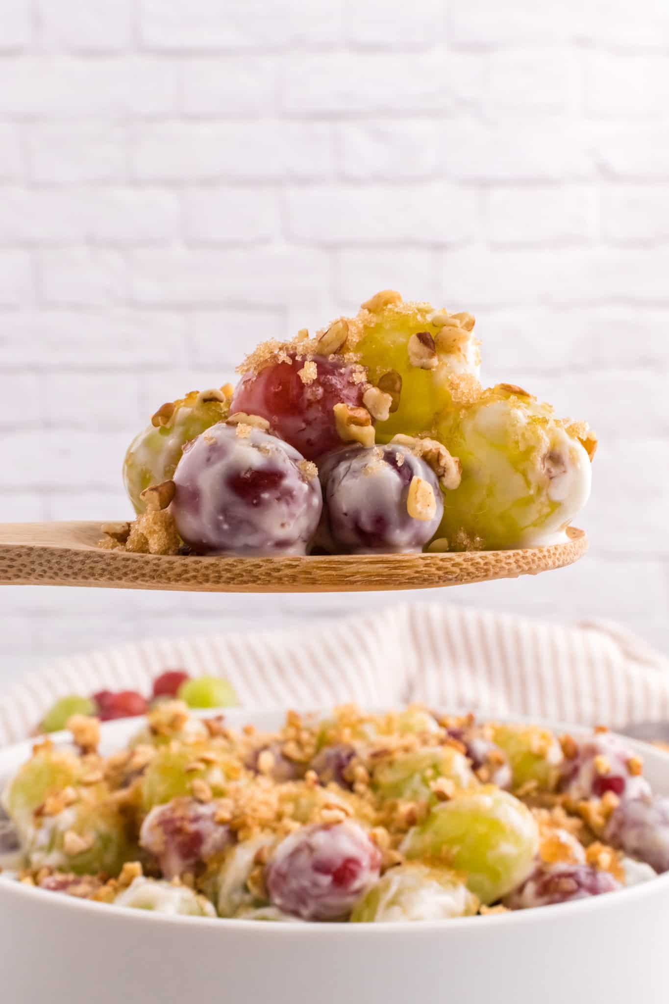 Grape Salad is a tasty side dish loaded with red and green grapes all tossed in a cream cheese and yogurt mixture and topped with brown sugar and chopped pecans.