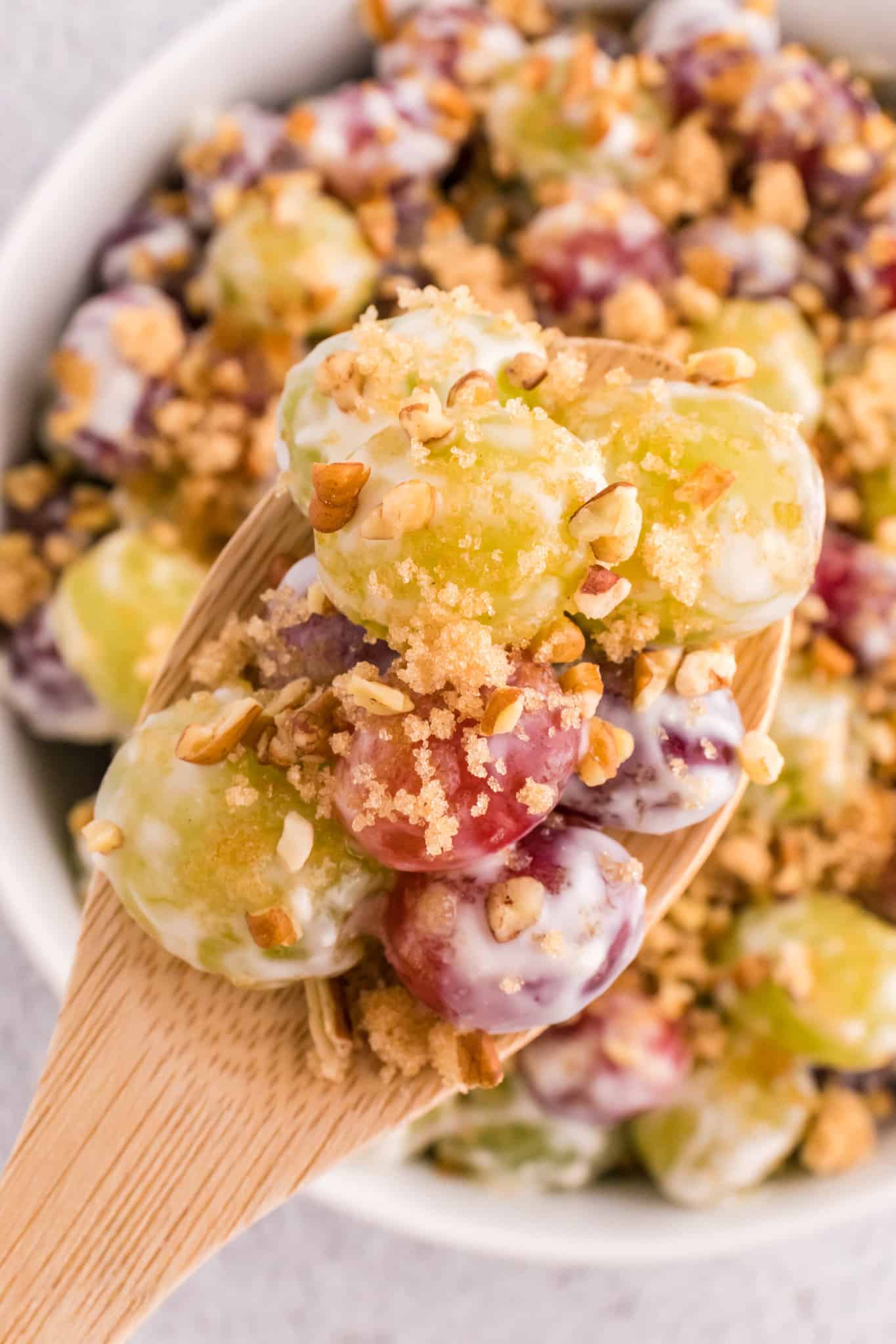 Grape Salad is a tasty side dish loaded with red and green grapes all tossed in a cream cheese and yogurt mixture and topped with brown sugar and chopped pecans.