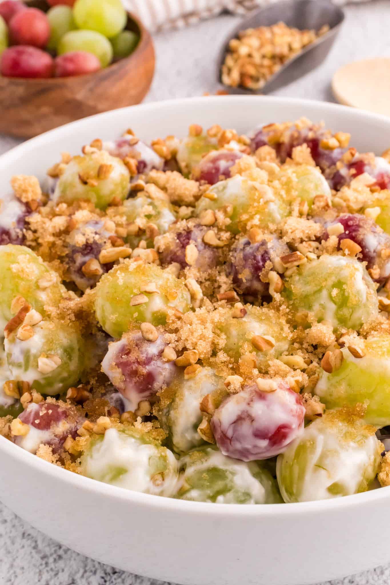 Grape Salad is a tasty side dish loaded with red and green grapes all tossed in a cream cheese and yogurt mixture and topped with brown sugar and chopped pecans.