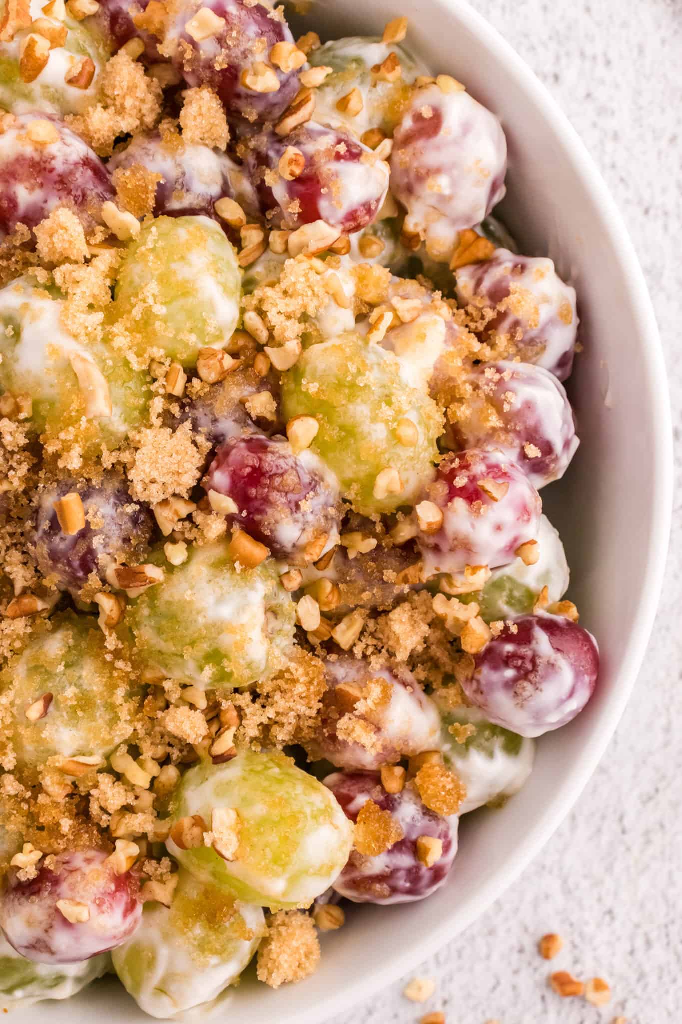 Grape Salad is a tasty side dish loaded with red and green grapes all tossed in a cream cheese and yogurt mixture and topped with brown sugar and chopped pecans.