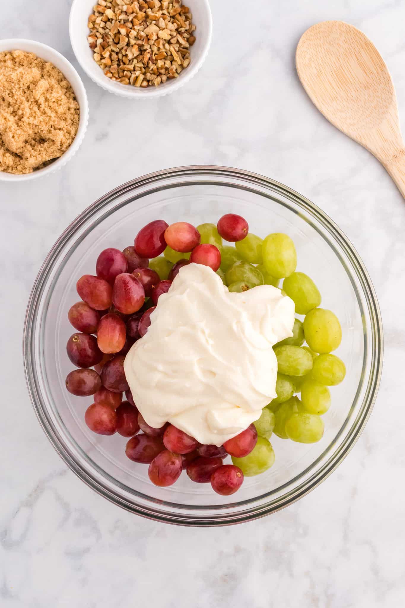 cream cheese and yogurt mixture on top of grapes in a bwol