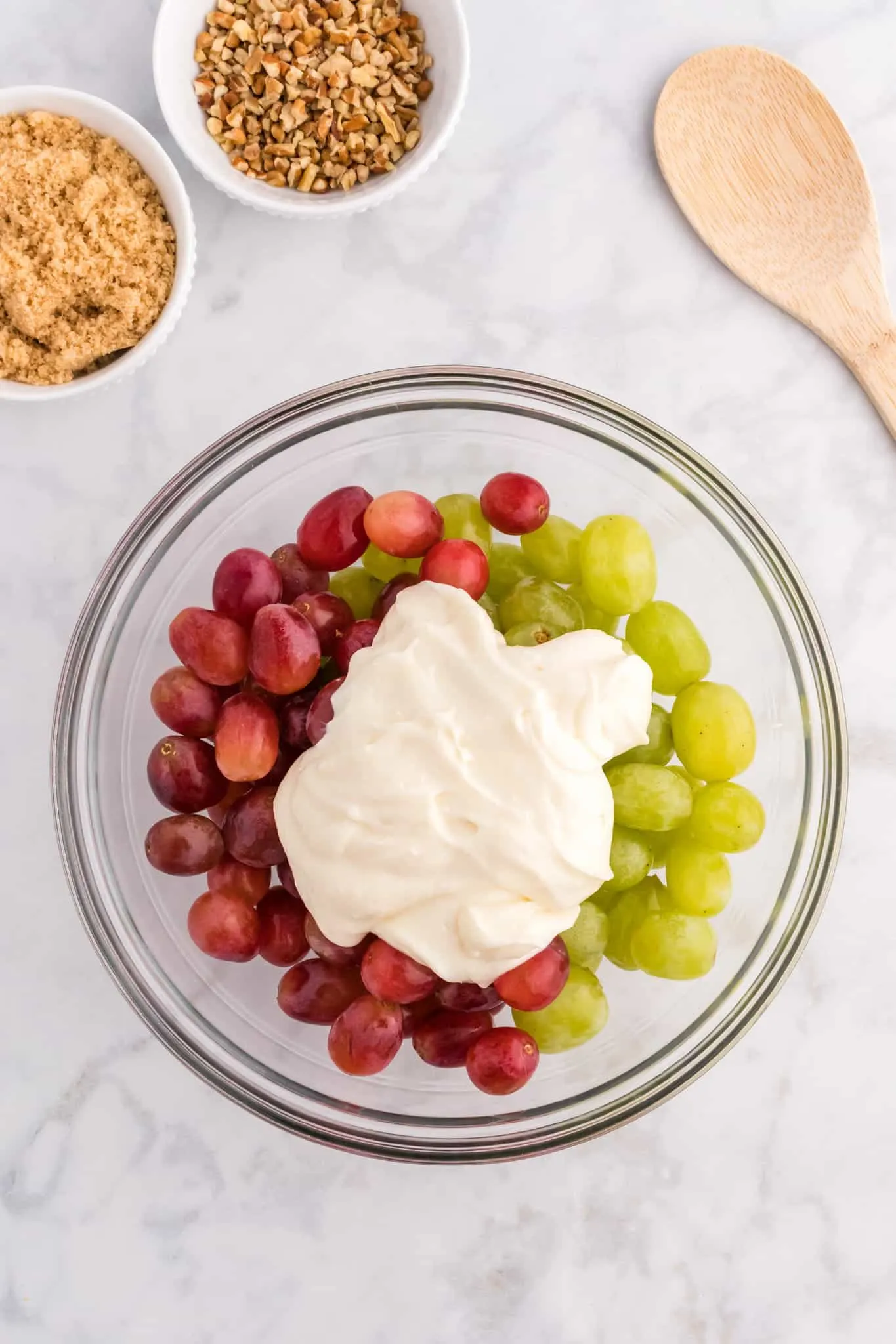 cream cheese and yogurt mixture on top of grapes in a bwol