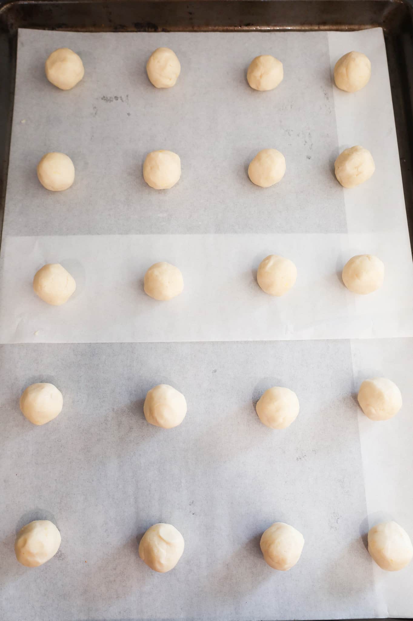 shortbread dough balls on a parchment lined baking sheet
