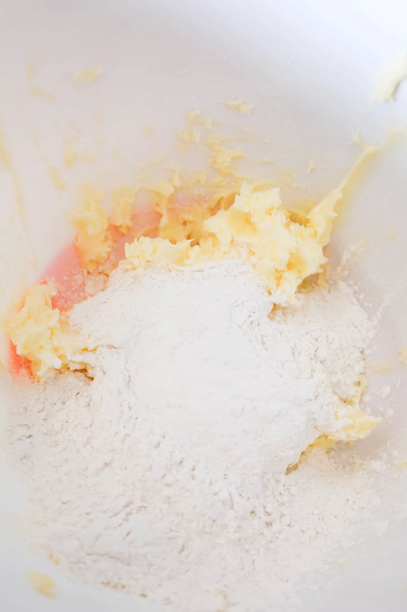 cornstarch and flour on top of creamed butter and sugar mixture in a mixing bowl