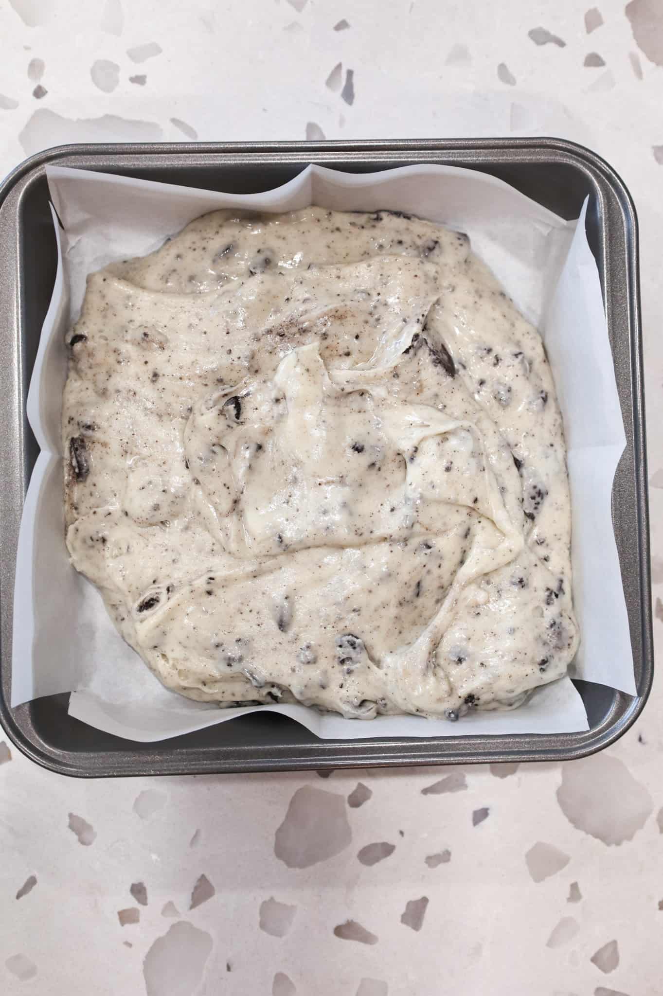 white chocolate and Oreo mixture in a parchment lined baking pan