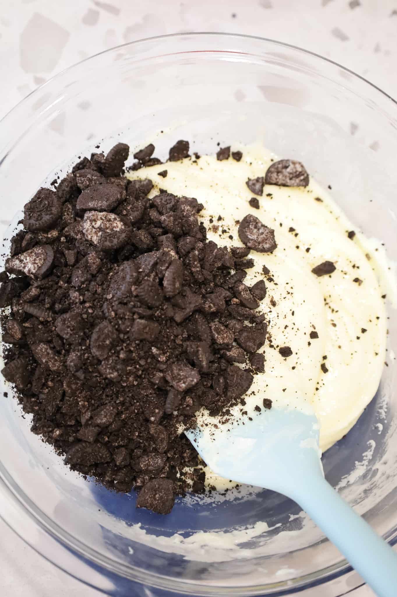 crumbled Oreos added to bowl with white chocolate mixture