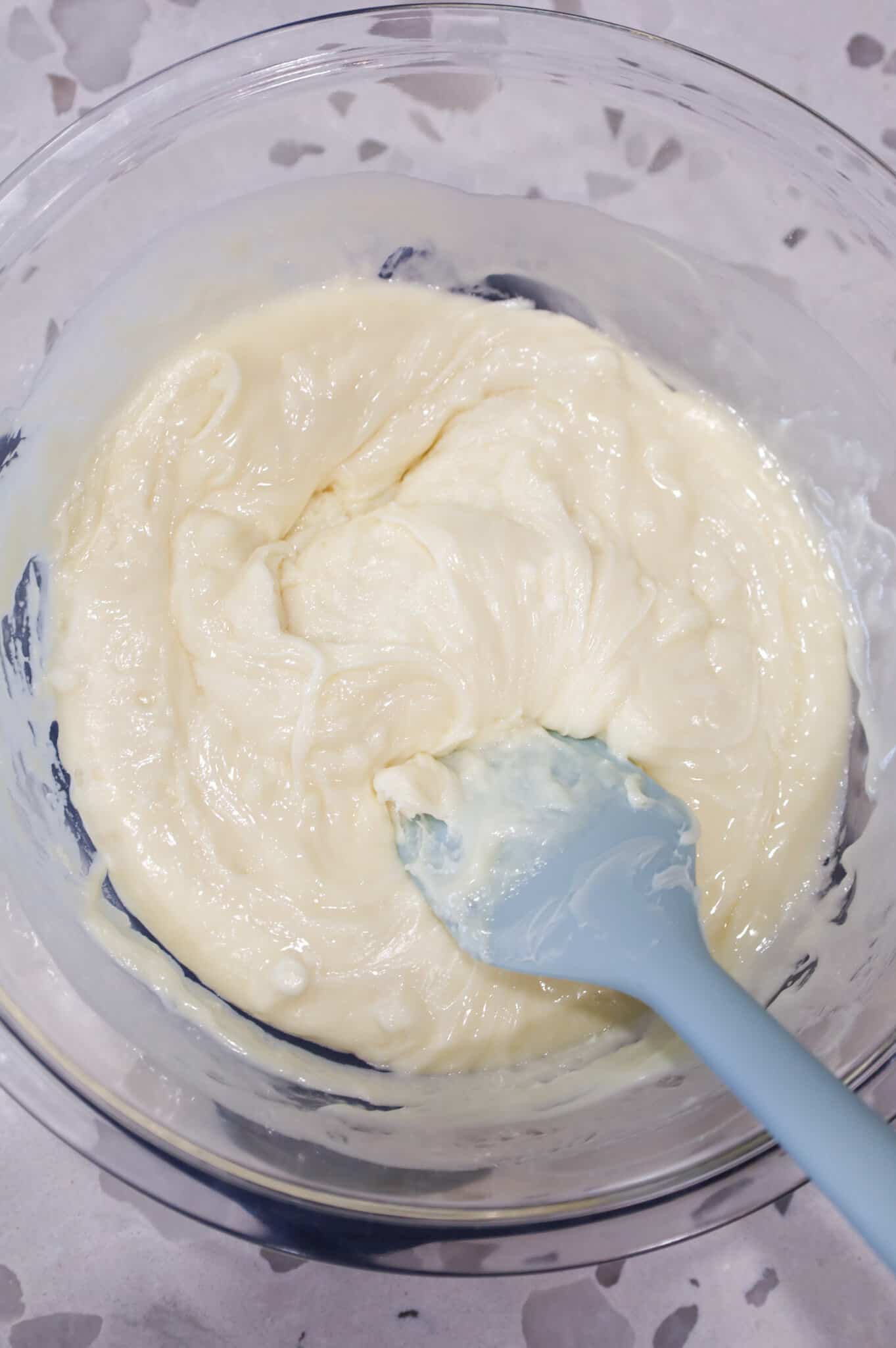 stirring white chocolate chips and vanilla frosting in a bowl