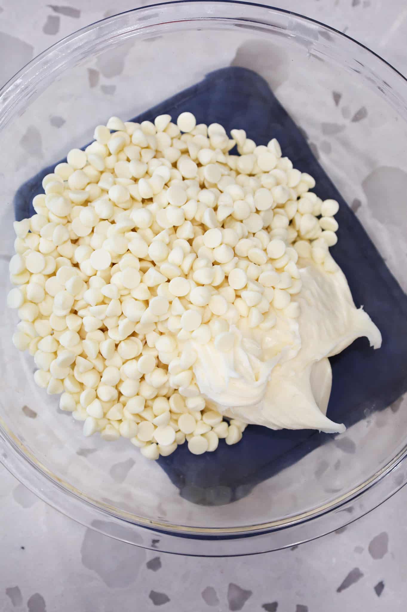 vanilla frosting and white chocolate chips in a bowl