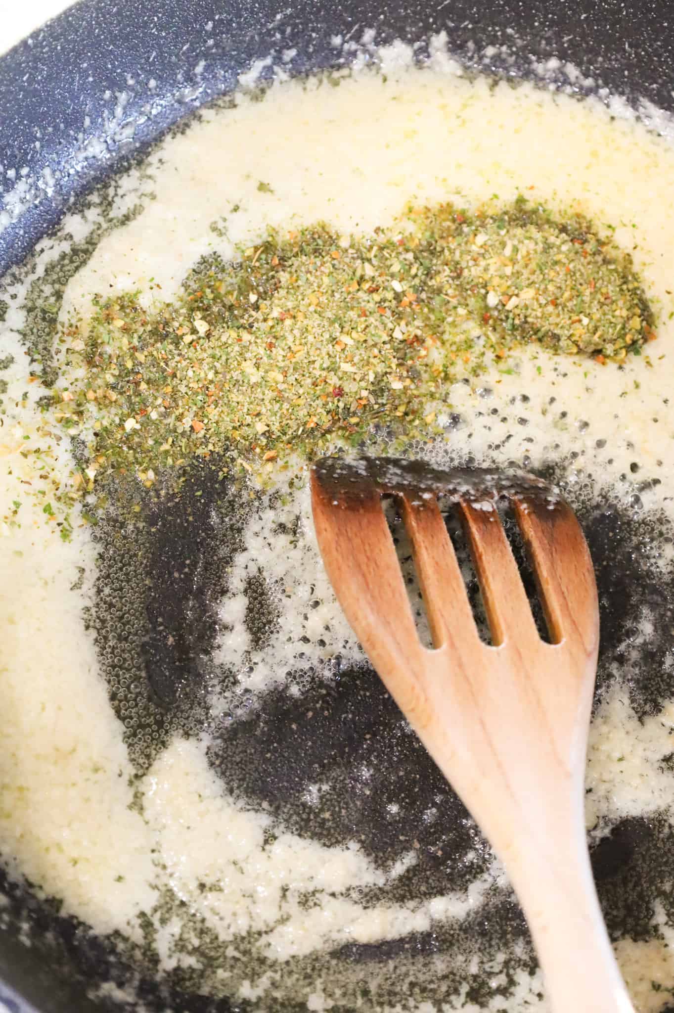 Italian seasoning added to skillet with melted butter and garlic puree