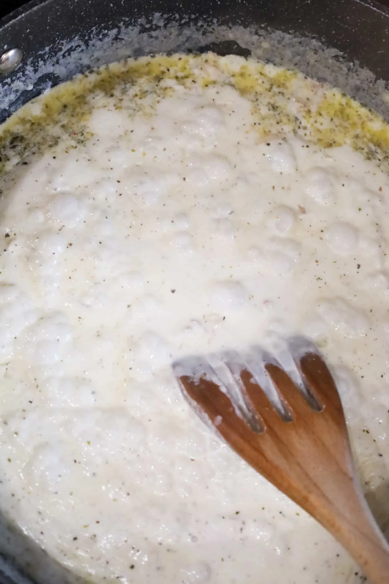 bringing cream sauce to a boil in a skillet