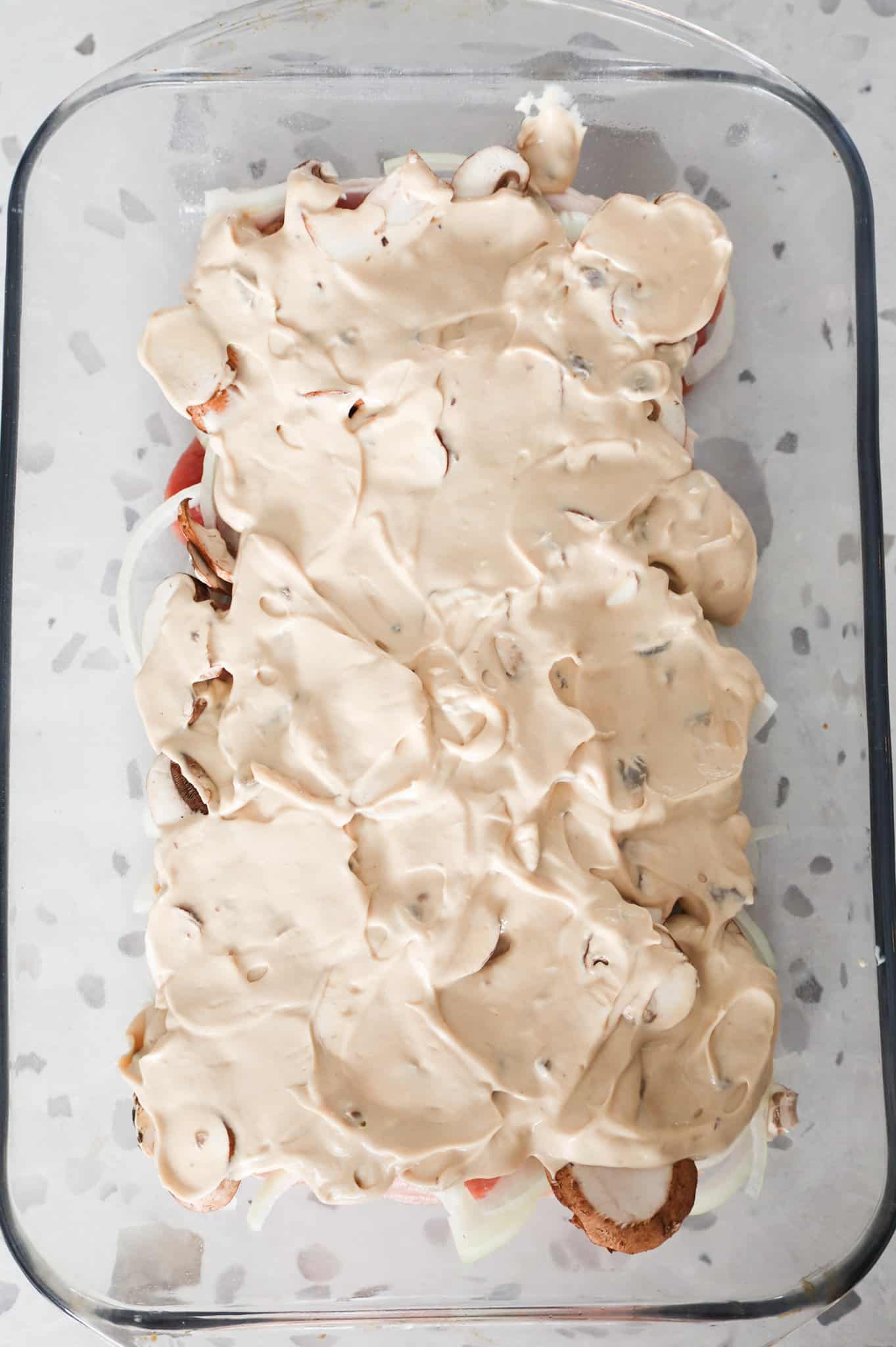 cream of mushroom soup mixture on top of pork chops in a baking dish