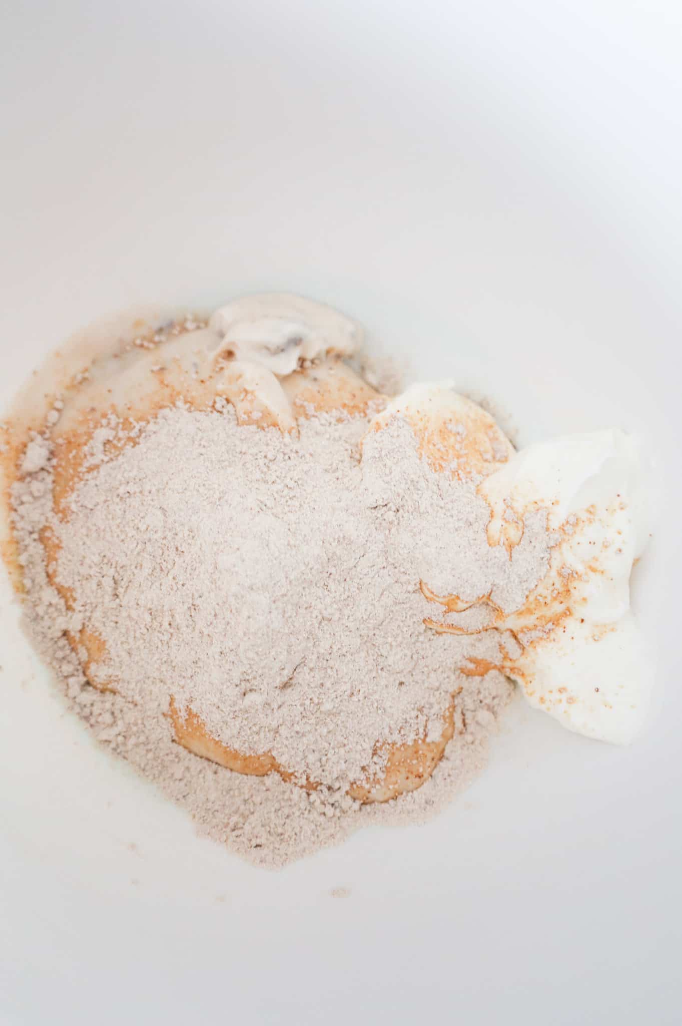 pork gravy mix on top of sour cream and cream of mushroom soup in a bowl