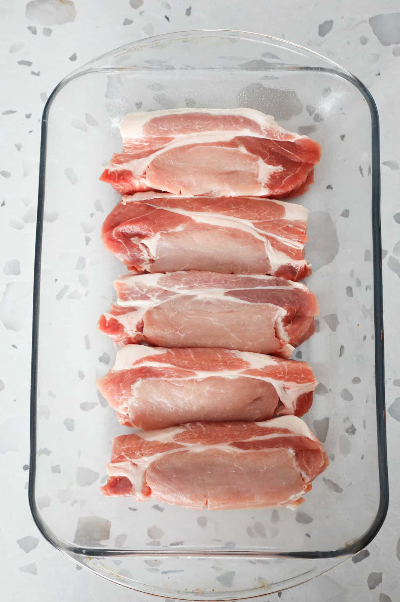 raw pork chops in a baking dish