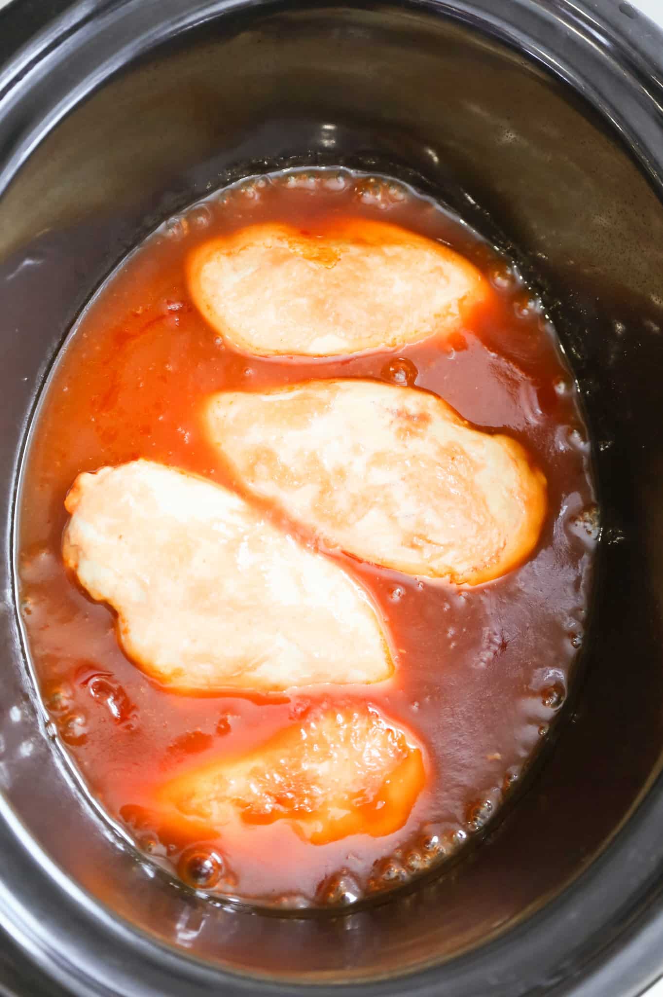 cooked chicken breast in lemonade sauce in a Crock Pot