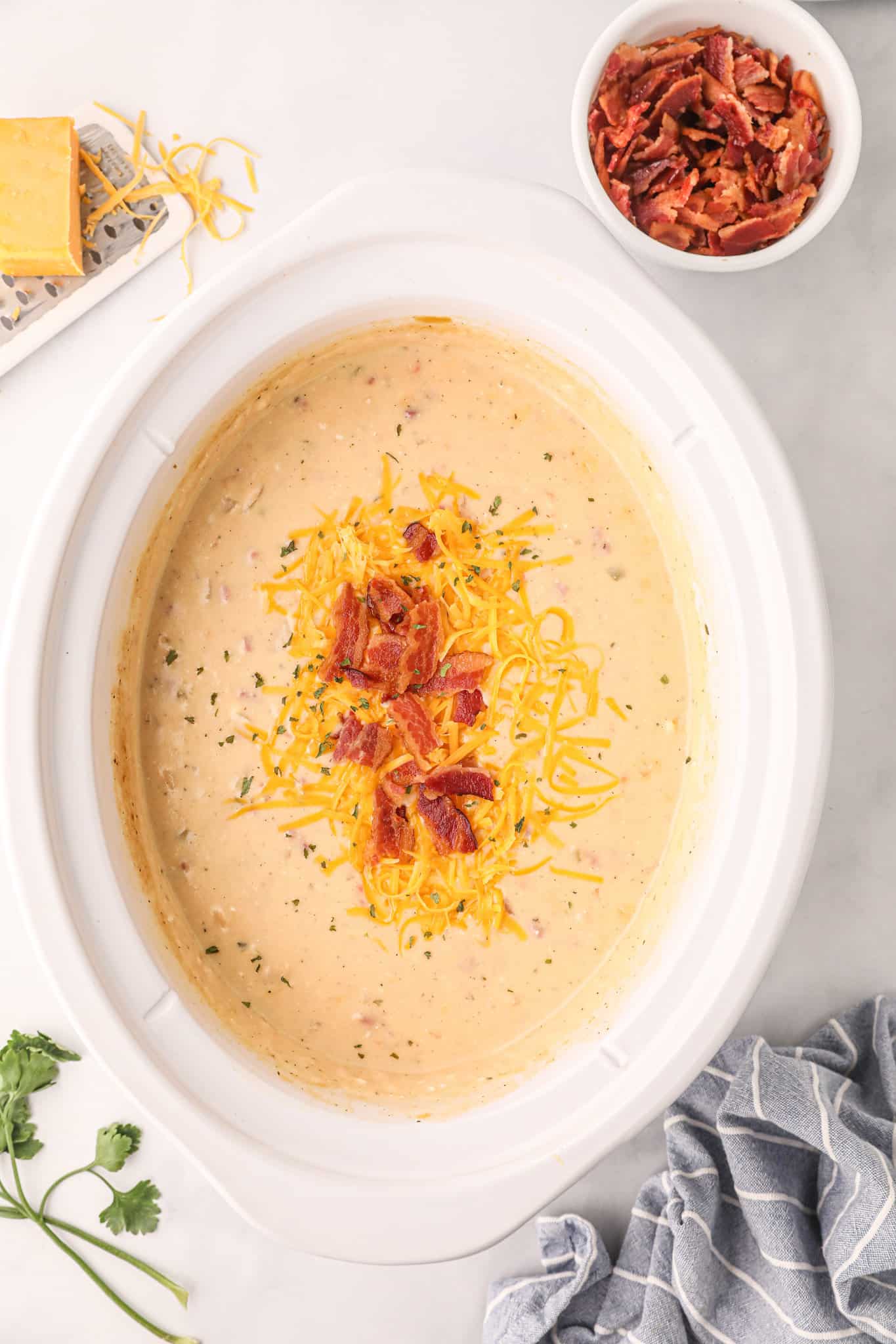 Crock Pot Loaded Potato Soup is a hearty slow cooker soup recipe loaded with diced hash brown potatoes, ham, cheddar cheese, cream cheese and bacon.