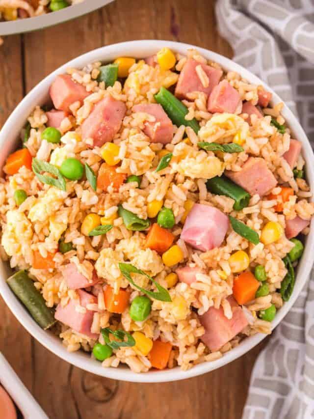 Ham Fried Rice is a delicious dinner or side dish recipe using diced ham, scrambled eggs and frozen mixed veggies all tossed with rice, soy sauce and fried rice seasoning mix.