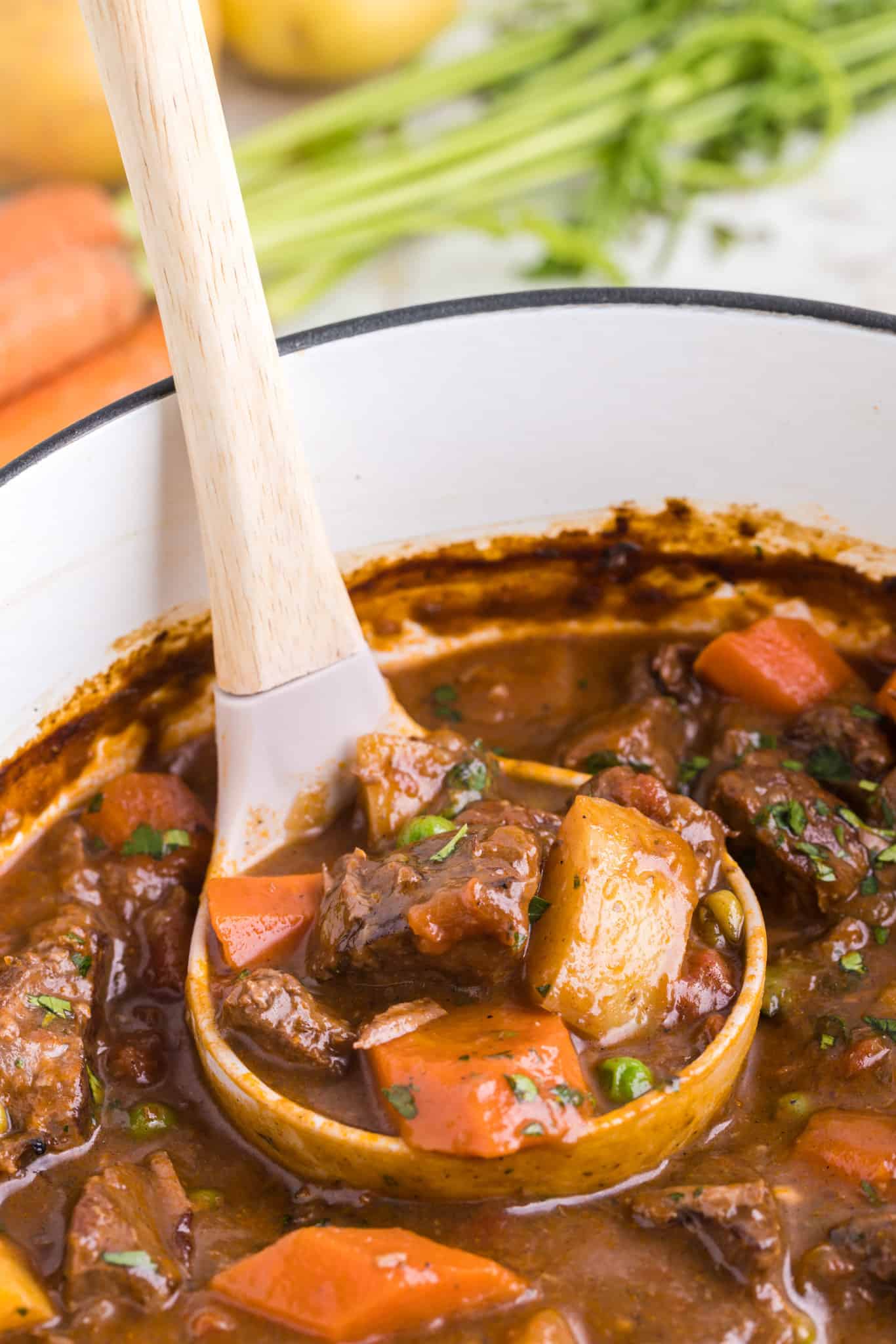 Dutch Oven Beef Stew is a hearty dish loaded with chunks of beef, carrots, onions, potatoes, tomatoes and peas.