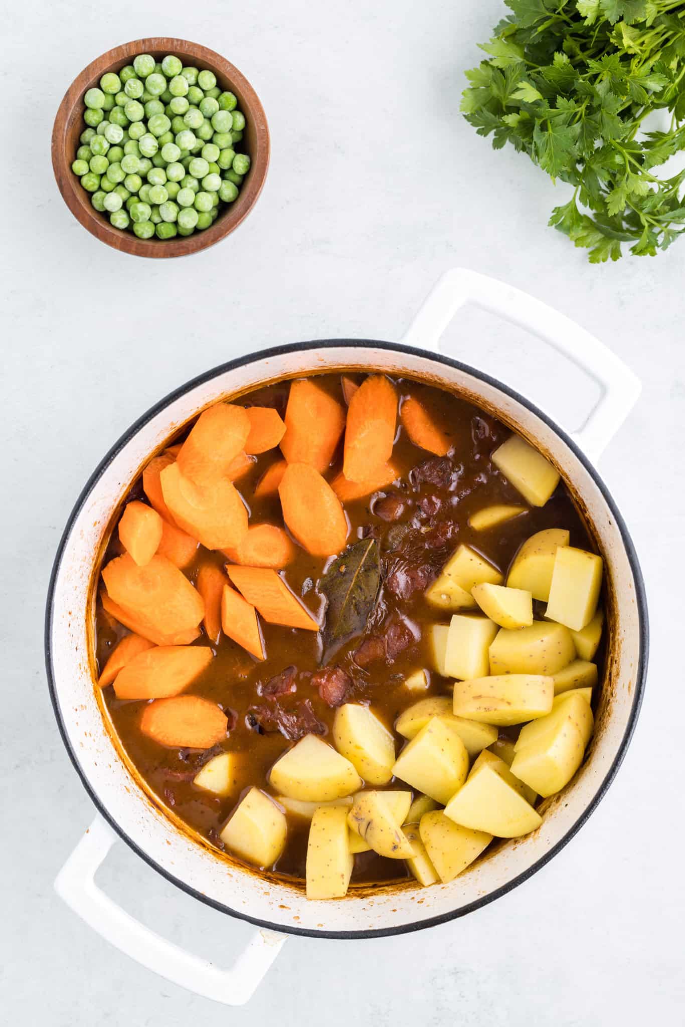 chopped carrots and potatoes added to beef stew pot