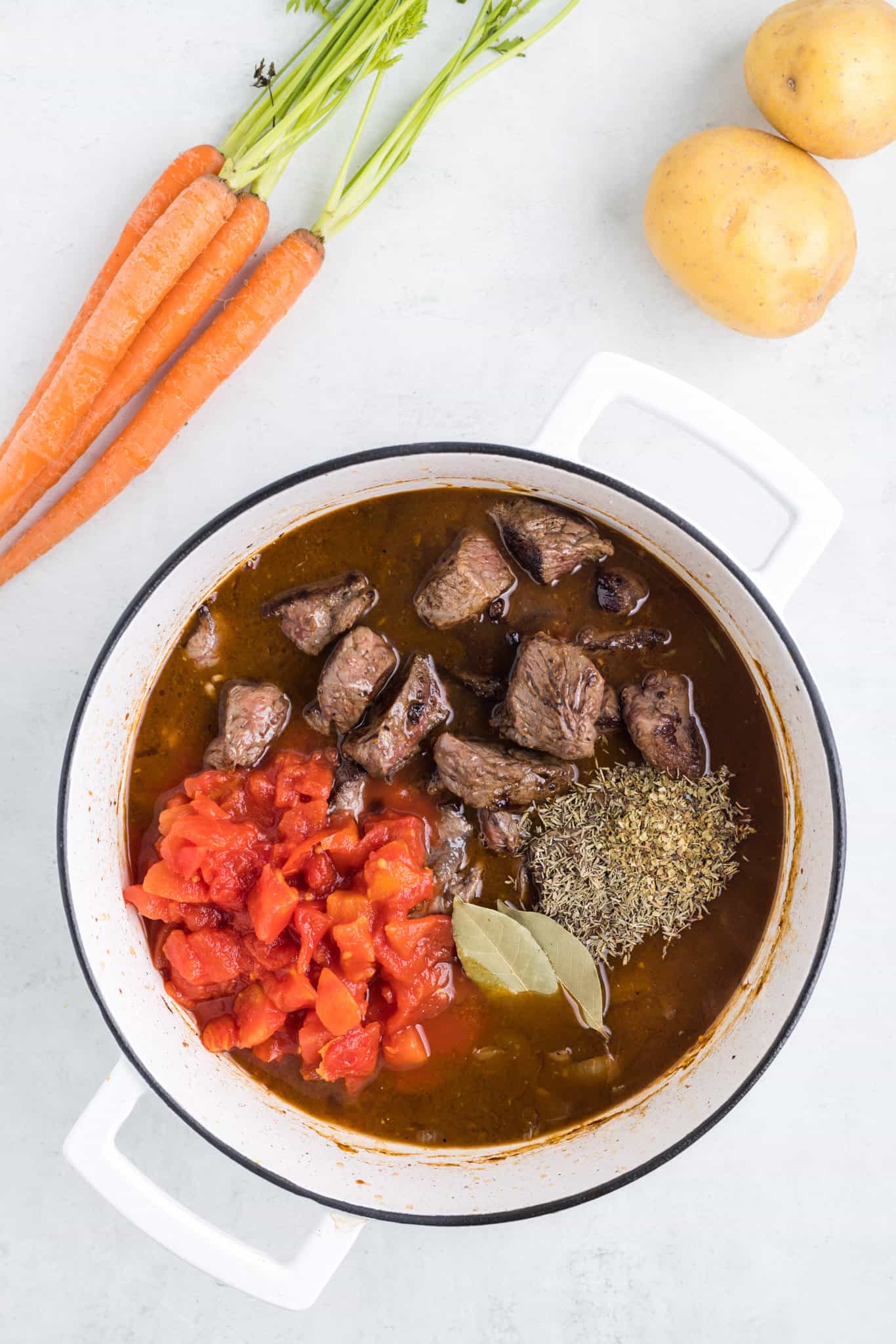 beef stock, diced tomatoes and spices added to Dutch oven