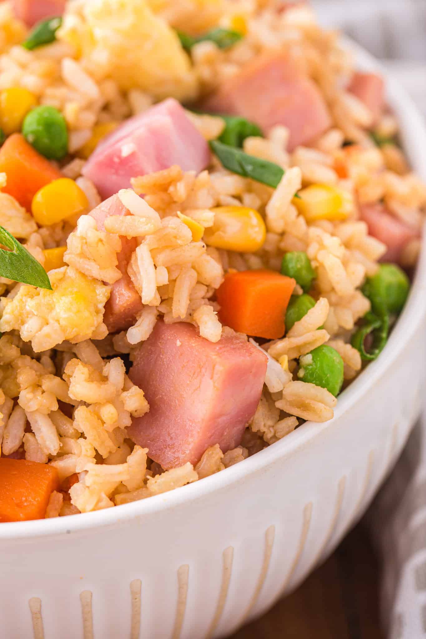 Ham Fried Rice is a delicious dinner or side dish recipe using diced ham, scrambled eggs and frozen mixed veggies all tossed with rice, soy sauce and fried rice seasoning mix.