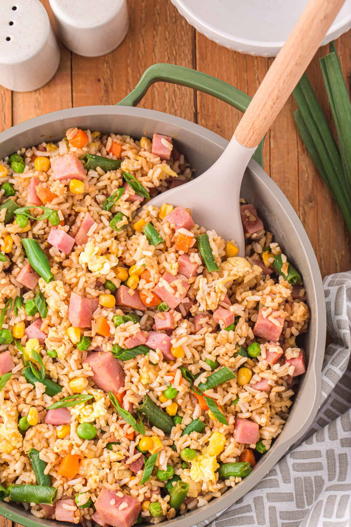 Ham Fried Rice is a delicious dinner or side dish recipe using diced ham, scrambled eggs and frozen mixed veggies all tossed with rice, soy sauce and fried rice seasoning mix.