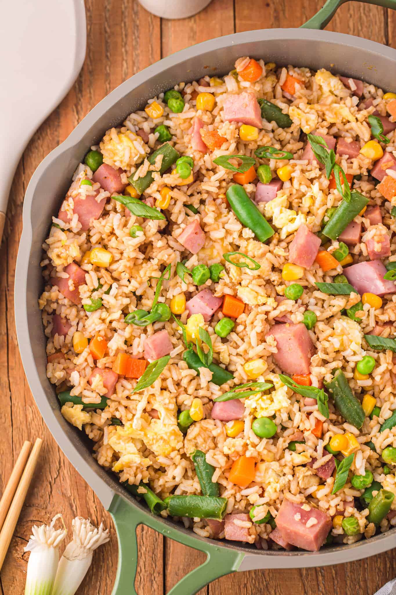 Ham Fried Rice is a delicious dinner or side dish recipe using diced ham, scrambled eggs and frozen mixed veggies all tossed with rice, soy sauce and fried rice seasoning mix.