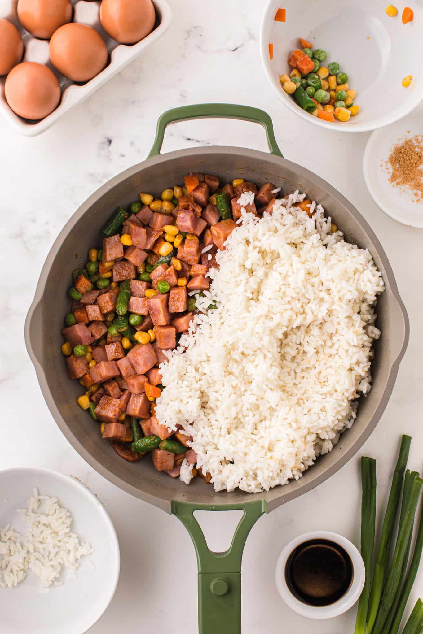 cooked rice added to skillet with diced ham and mixed veggies.