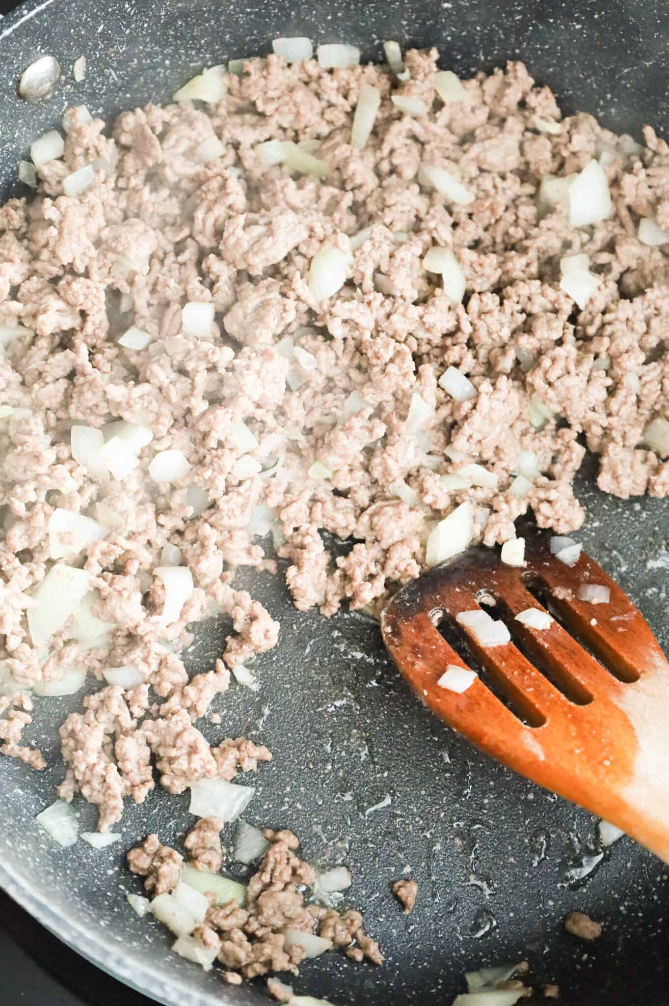 cooked ground beef and diced onions in a skillet