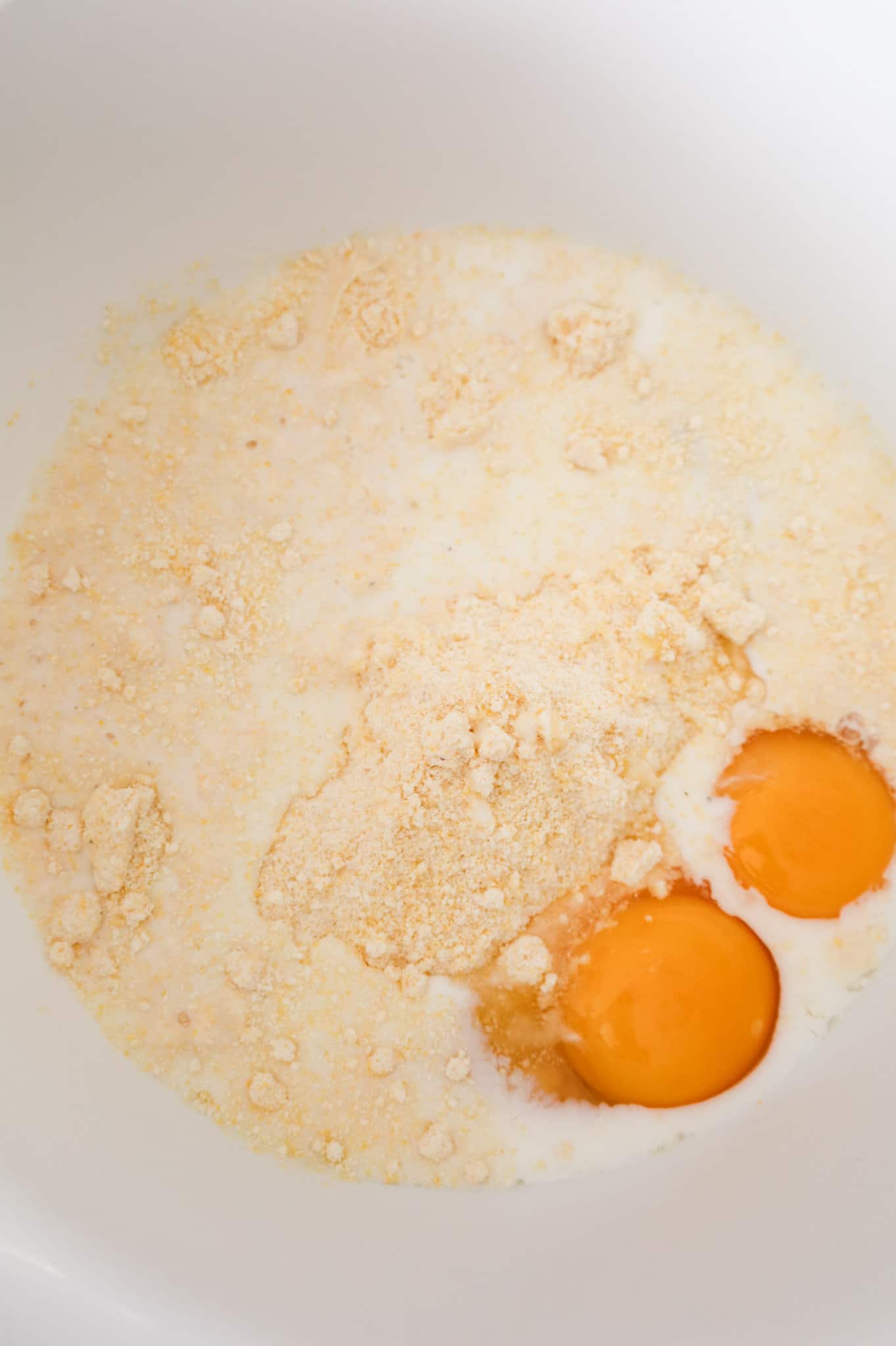 Jiffy cornbread mix, milk and eggs in a mixing bowl