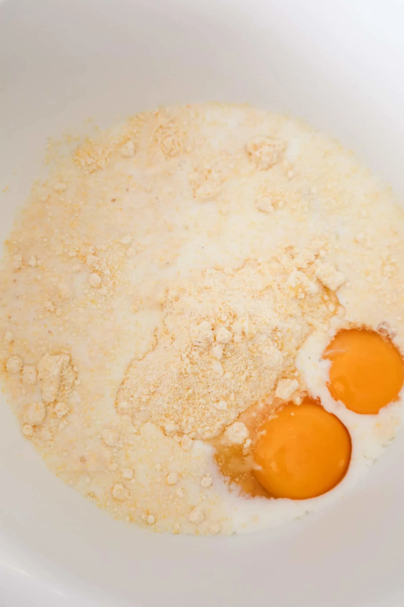 Jiffy cornbread mix, milk and eggs in a mixing bowl