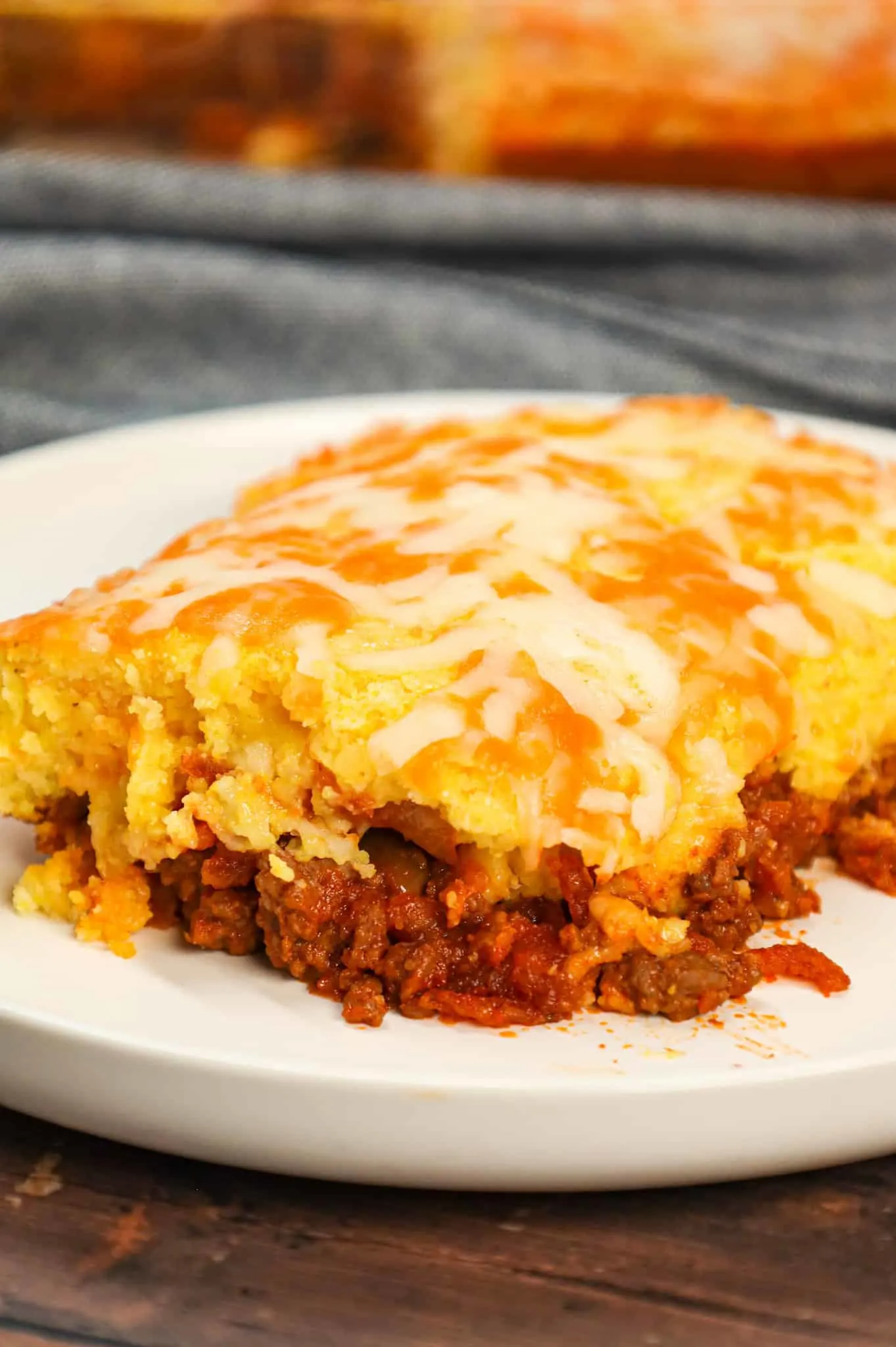 Sloppy Joe Cornbread Casserole is a hearty hamburger casserole with a base of crumbled ground beef in sloppy joe sauce topped with a layer of Jiffy cornbread.