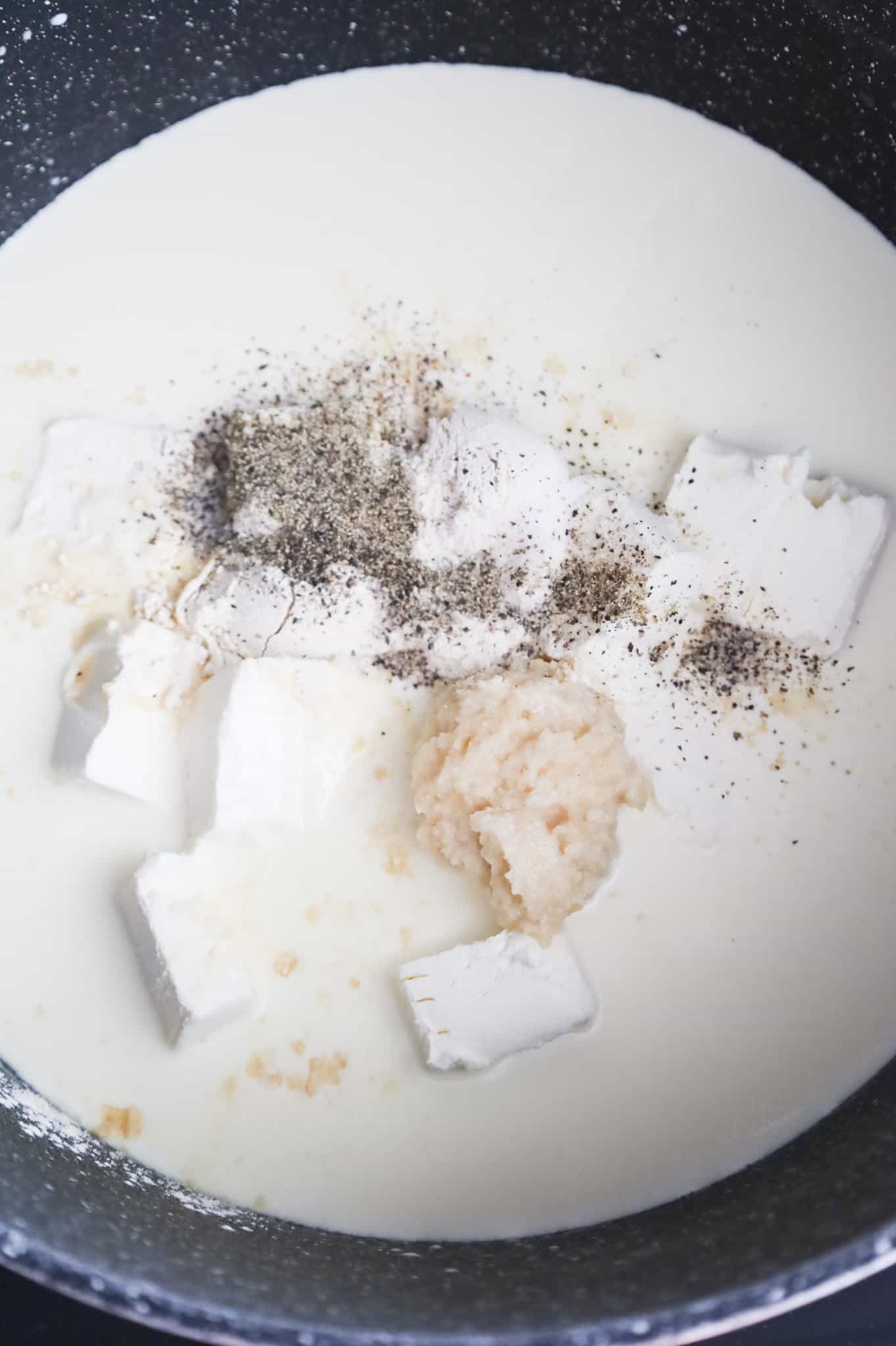 salt, pepper, garlic puree and cubes of cream cheese in a pot with heavy cream