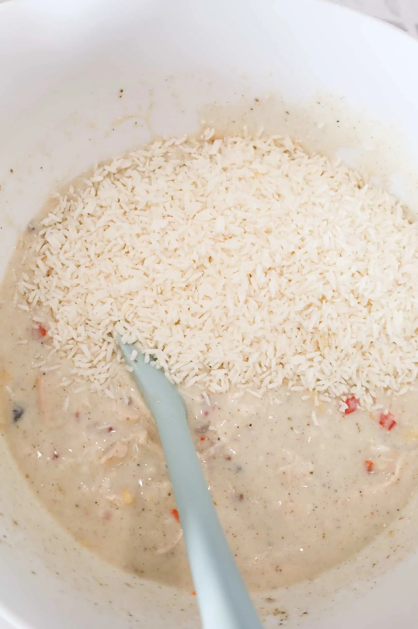 instant rice added to bowl with cream soup and chicken mixture