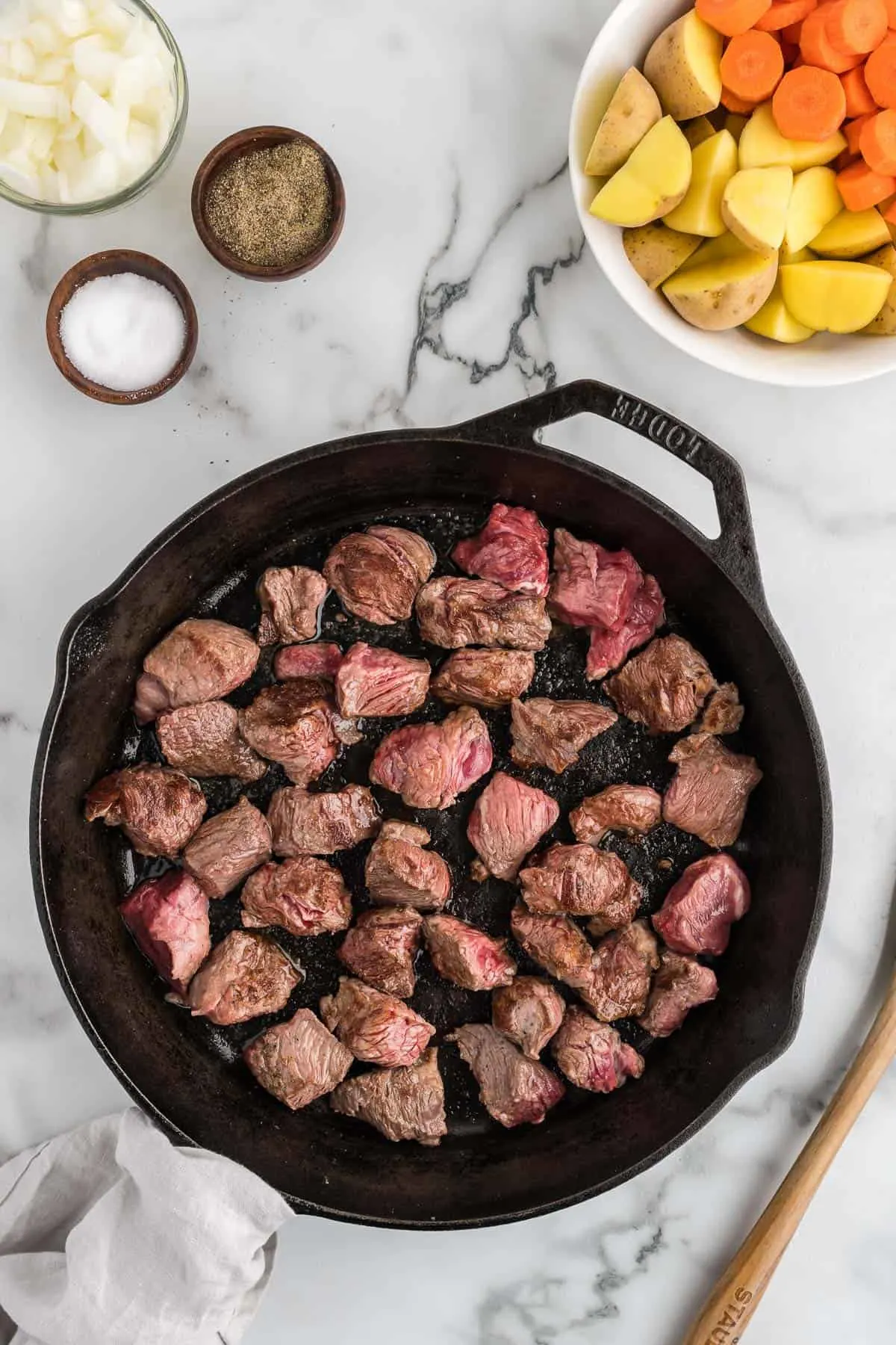 beef chunks searing in a skillet