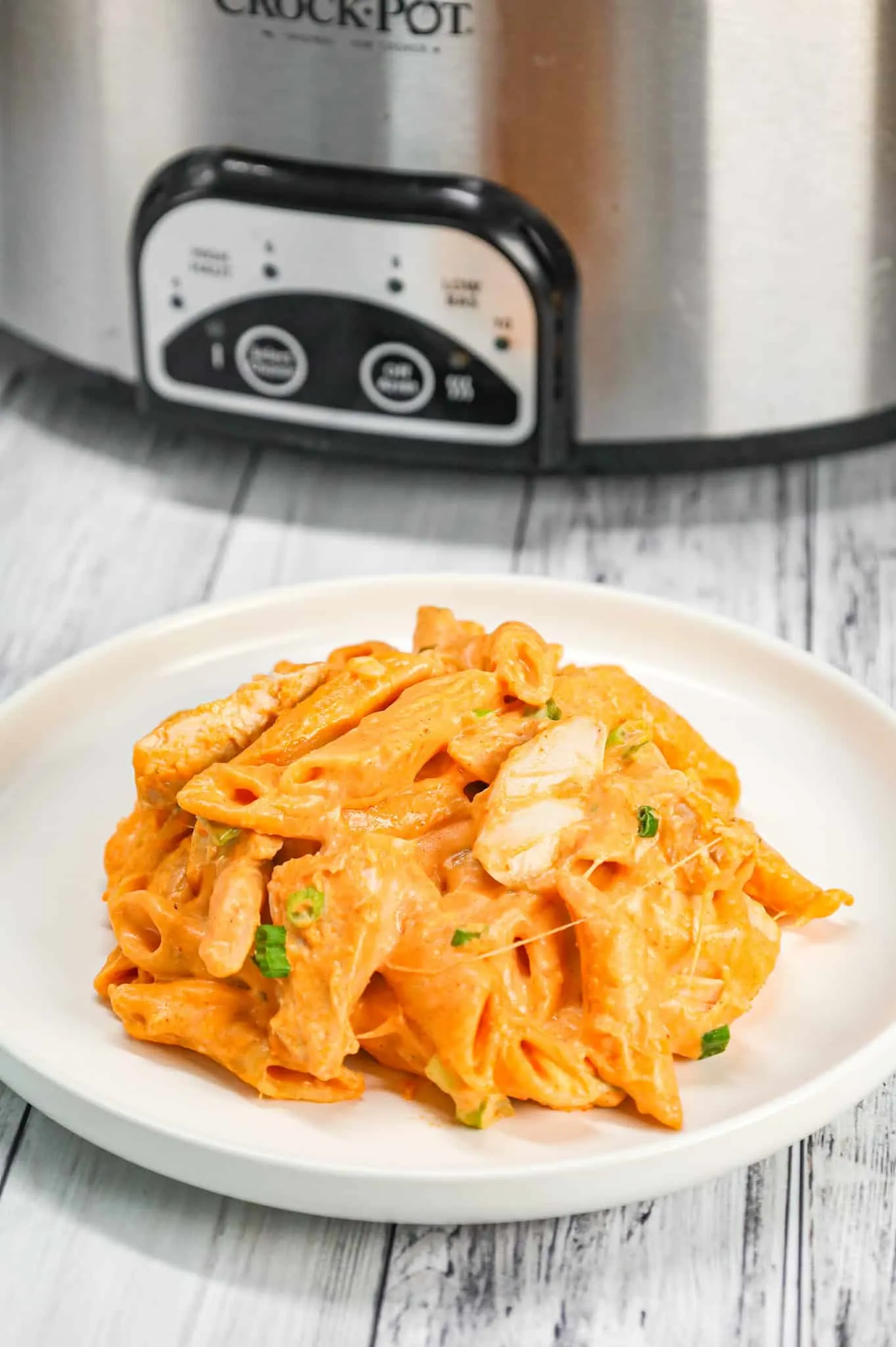 Crock Pot Buffalo Chicken Pasta is an easy slow cooker penne recipe loaded with Buffalo sauce, ranch dressing, cream cheese, breast chunks, cheddar, mozzarella and chopped green onions.