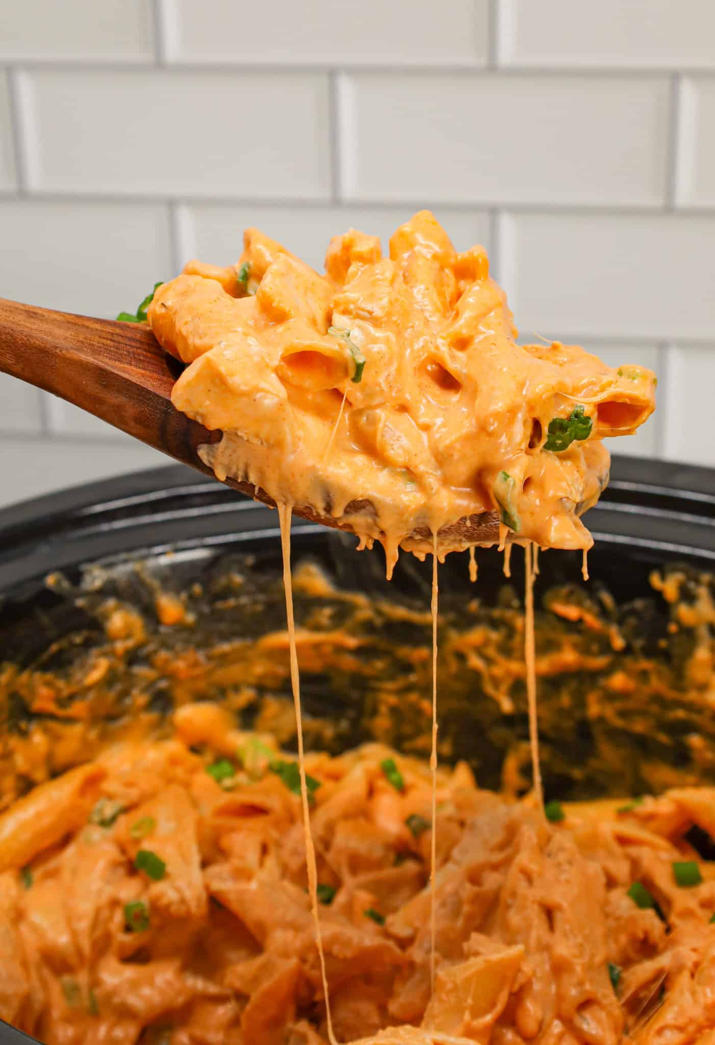 Crock Pot Buffalo Chicken Pasta is an easy slow cooker penne recipe loaded with Buffalo sauce, ranch dressing, cream cheese, breast chunks, cheddar, mozzarella and chopped green onions.