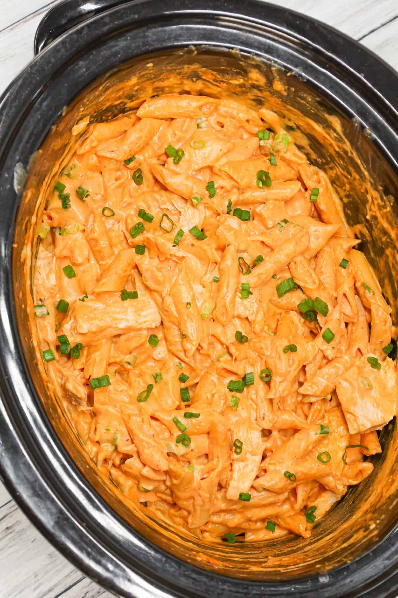 Crock Pot Buffalo Chicken Pasta is an easy slow cooker penne recipe loaded with Buffalo sauce, ranch dressing, cream cheese, breast chunks, cheddar, mozzarella and chopped green onions.