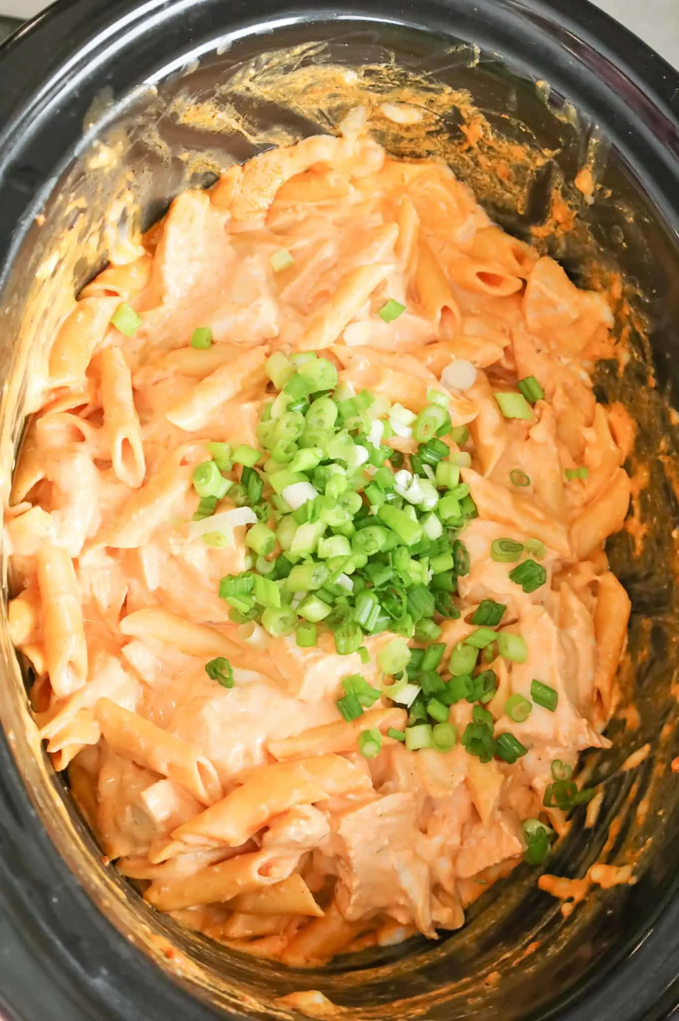 chopped green onions added to crock pot with Buffalo chicken pasta